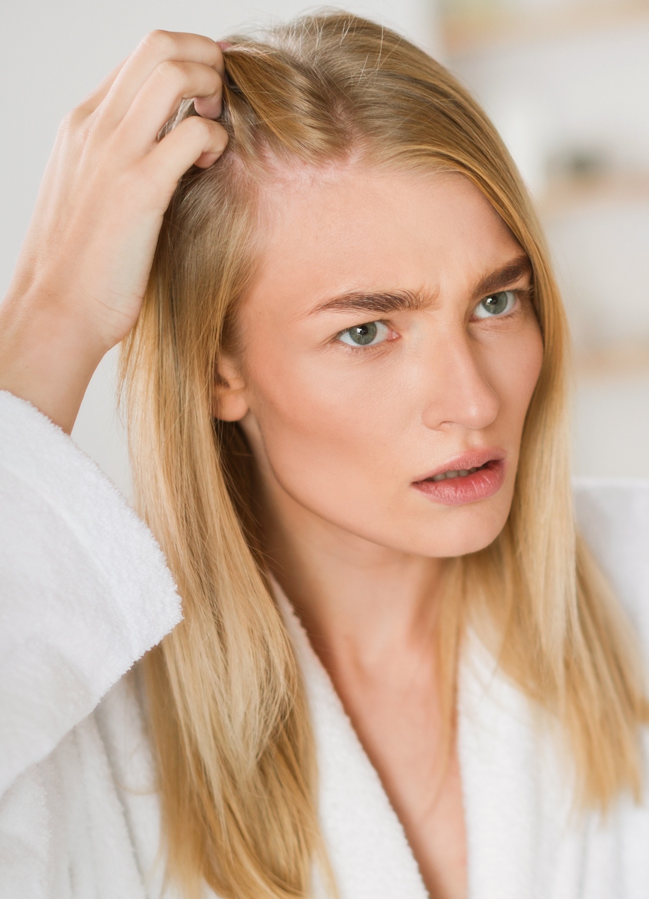 Woman checking hair for loss - Nutrafol hair growth consultations CityHealth Oakland